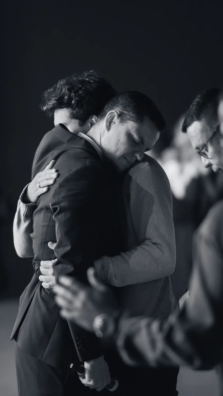 Irmãos abraçados em oração durante o culto